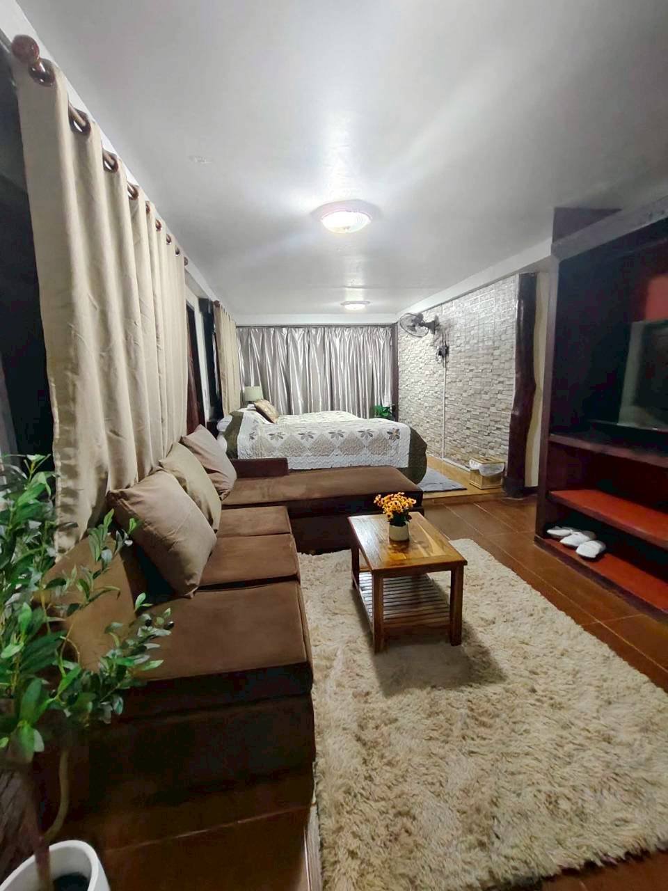 Family suite room detail with sofa, bed and warm wooden interior